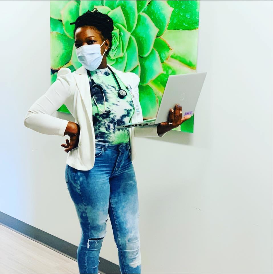 Sonsie Brown in clinical attire holding laptop